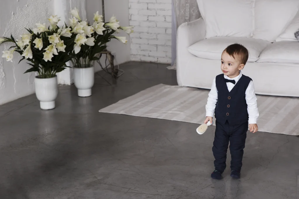 Elegáns ruhába öltözött kisfiú pózol műtermi babafotózáson