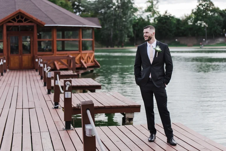 Gyömrői tónál tartott esküvőn zsebre tett kézzel néz oldalra a vőlegény