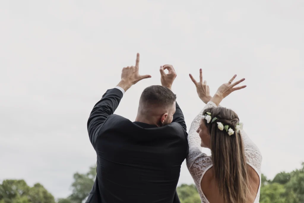 Love, szerelmüket ujjaikkal ábrázoló ifjú pár esküvőjük napján