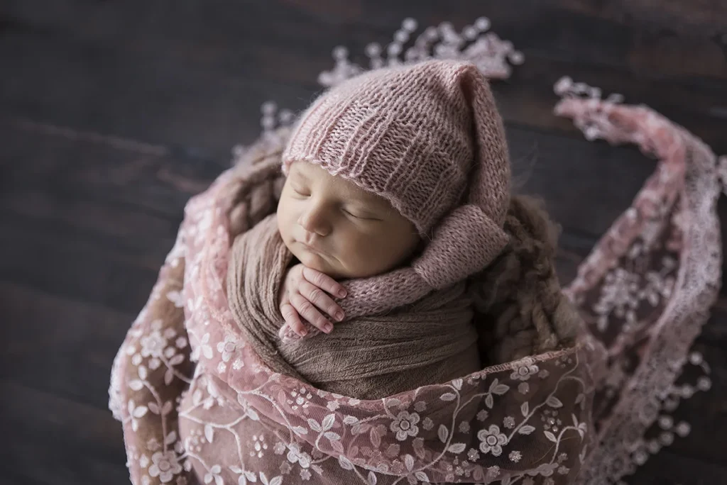 Kezdőlap Rózsaszín anyagba tekert újszülött baba portré alvás közben, közelről fényképezve